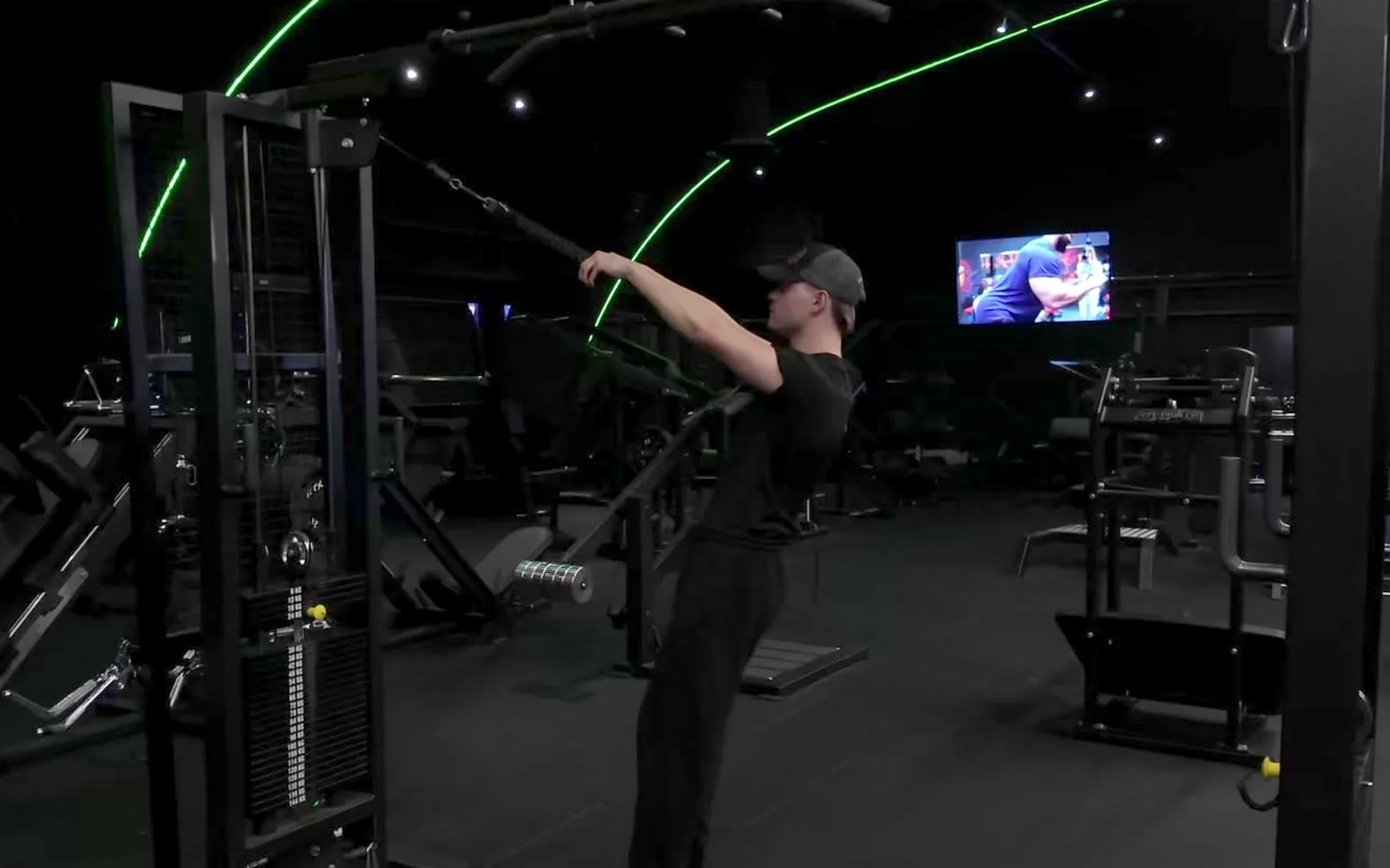 Mies vetää taljan köyttä kasvoja kohti face pull -liikkeessä kuntosalilla